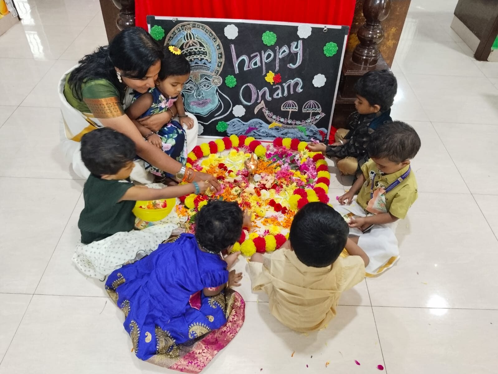 Children celebrating Onam with a flower rangoli
